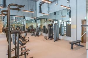 a gym with rows of exercise bikes and treadmills at Heaven Crest Holiday Homes - Luxury Forte in Dubai
