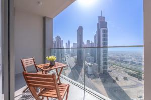 a balcony with a table and chairs and a view of the city at Heaven Crest Holiday Homes - Luxury Forte in Dubai