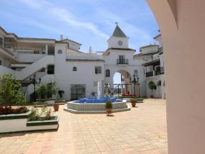 une cour avec une fontaine en face d'un bâtiment dans l'établissement Pueblo Quinta, à Benalmádena