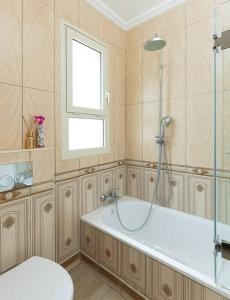 e bagno con vasca, finestra e doccia. di Jerusalem of Gold 4 BR Apartment a Gerusalemme