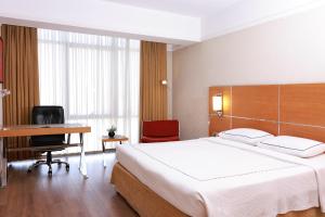 a bedroom with a large bed and a desk at Anemon Grand Denizli Otel in Denizli