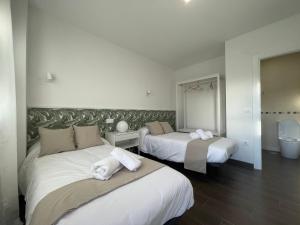 Habitación de hotel con 2 camas y toallas. en Hostería La milla Rural, 