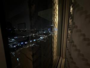 - une vue sur la ville la nuit depuis une fenêtre dans l'établissement The 23rd Haven by Kasara Urban Resort Residences, à Manille