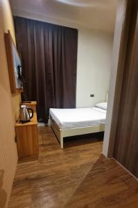 1 dormitorio con cama blanca y ventana en Eekos Hotels en Baguio