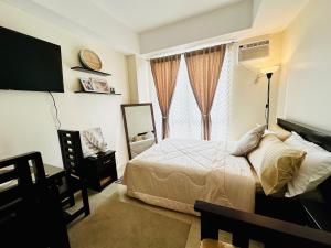 - une chambre avec un lit et une grande fenêtre dans l'établissement The 23rd Haven by Kasara Urban Resort Residences, à Manille