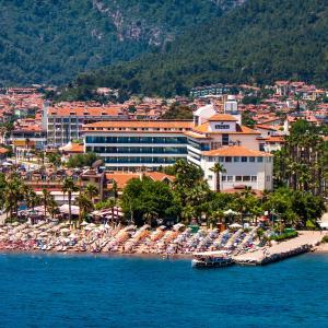 a beach with a bunch of umbrellas and a resort at Letoile Beach Hotel in Marmaris