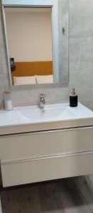 La salle de bains est pourvue d'un lavabo blanc et d'un miroir. dans l'établissement Louridoplaya, à Poio