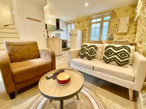 een woonkamer met een bank, een stoel en een tafel bij Montignac-Lascaux - Les Pierres De Lascaux in Montignac