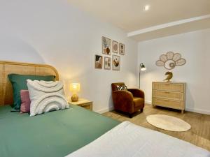 een slaapkamer met een groen bed en een stoel bij Montignac-Lascaux - Les Pierres De Lascaux in Montignac