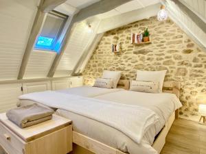 a bedroom with a large bed in a stone wall at Montignac-Lascaux - Les Pierres De Lascaux in Montignac +20 photos
