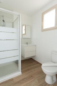 a white bathroom with a toilet and a mirror at Le Noyer - moderne - spacieux - parking in Montaigu-Vendée