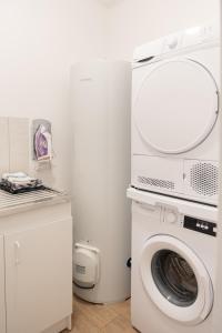 a laundry room with a washing machine and a washer at Le Noyer - moderne - spacieux - parking in Montaigu-Vendée