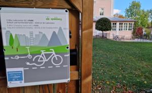 a sign on a fence with a bike on it at Hotel Villa Sisi in Pöcking