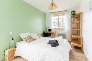 a bedroom with a white bed and a desk at Le Noyer - moderne - spacieux - parking in Montaigu-Vendée