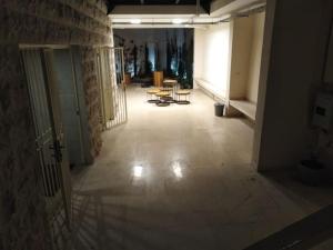 an empty hallway with tables and chairs in a building at No7 Boutique Apartments in Amman