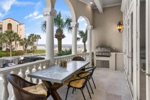 een balkon met een tafel en stoelen en uitzicht op het strand bij Sea-Esta - 1136 Postell in East End