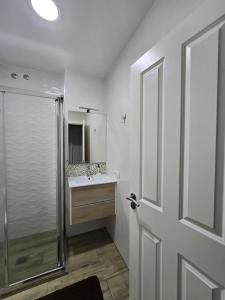 a white bathroom with a shower and a sink at Mi Rincon en La Pedrera in Tejina