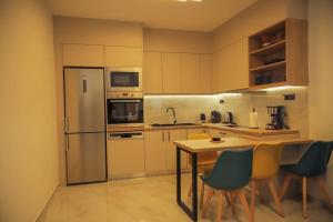 a kitchen with a refrigerator and a table and chairs at Αntonia πολυτελείς διαμονή στο χωριό Λιγόρτινος! in Heraklio Town