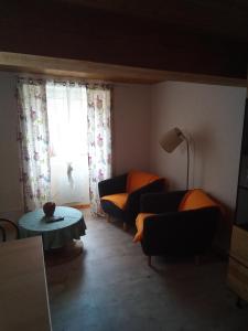 - un salon avec deux canapés, une table et une fenêtre dans l'établissement Bienvenu à la campagne, à La Roche-sur-Yon