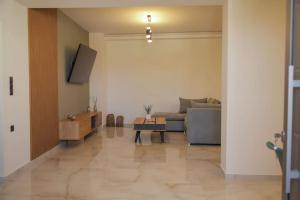 a living room with a couch and a table at Αntonia πολυτελείς διαμονή στο χωριό Λιγόρτινος! in Heraklio Town