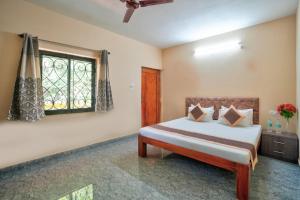 a bedroom with a bed and a window at Golden Studio Apartment Goa in Calangute