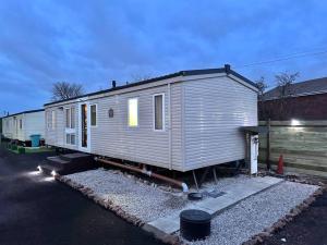 a tiny house is parked in a parking lot at Atlas 2 Bedroom Caravan, Glasgow in Uddingston