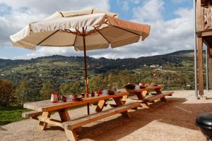 a picnic table with an umbrella on a patio at La Grange des Mios in La Bresse