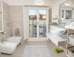 baño con 2 lavabos, aseo y ventana en Appartamento Matilde, en Turín