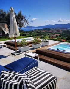 a patio with an umbrella and a swimming pool at Aethalia Bed and Breakfast in Portoferraio