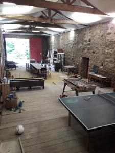 una stanza con tavoli da ping pong e un muro di mattoni di Terre et Eau La chambre d'hôtes du jardinier Sèvremont a Sevremont
