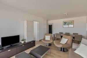 a living room with a couch and a television at Atalanta 0303 b2 2ev in Wenduine