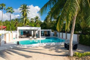 une villa avec piscine et palmiers dans l'établissement 塔羅别墅-直通海滩的三卧海滨别墅, à Koh Samui 