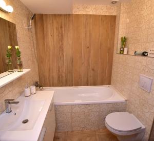 a bathroom with a tub and a toilet and a sink at Near Cathedral Central Studio in Bucharest