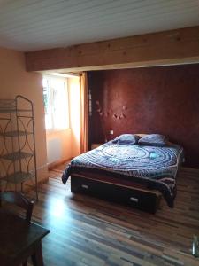 - une chambre avec un grand lit et un mur en bois dans l'établissement Bienvenu à la campagne, à La Roche-sur-Yon