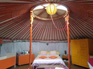 a bedroom with a bed in a yurt at Yourte et nature in Magnien
