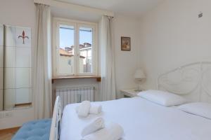 a bedroom with a white bed and a window at Suite Calvino, in Piazza Unità con parcheggio in Trieste