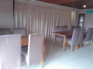 a dining room with a wooden table and chairs at Nomanini guest house Nelspruit in Nelspruit
