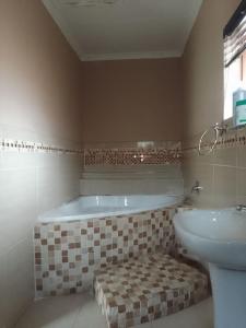 a bathroom with a tub and a sink at Nomanini guest house Nelspruit in Nelspruit