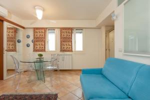 a living room with a blue couch and a table at Suite Calvino, in Piazza Unità con parcheggio in Trieste