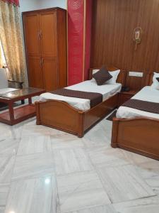 um quarto com 2 camas e uma mesa em HOTEL RIZ VARANASI em Varanasi