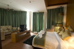 a large bedroom with a large bed and a couch at Hotel The Amaris in Rishīkesh