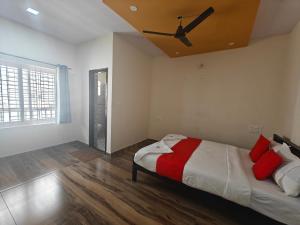 1 dormitorio con 1 cama y ventilador de techo en The Whispering Willows, en Mysore