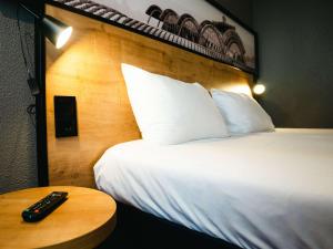 una camera da letto con un letto con un telecomando su un tavolo di Ibis Valladolid a Valladolid