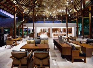 un ristorante con tavoli e sedie in legno e un edificio di Grand Hyatt Bali a Nusa Dua