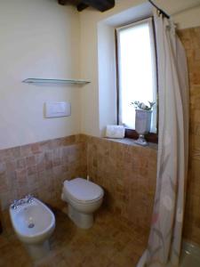 a bathroom with a toilet and a sink and a window at Private Villa Dolce Vita in Lucignano