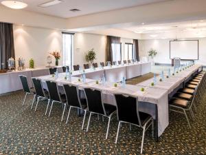 una gran sala de conferencias con una mesa larga y sillas en Mercure Gerringong Resort en Gerringong