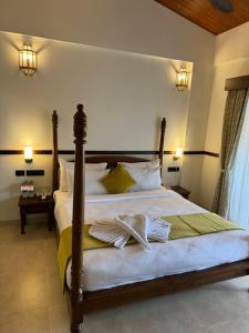 羅納瓦拉的住宿－Mastiff Grand La Villae，一间卧室配有一张床,上面有两条毛巾