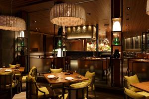 a restaurant with tables and chairs and chandeliers at Grand Hyatt Fukuoka in Fukuoka