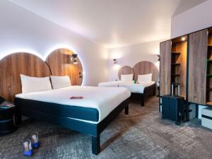 a hotel room with two beds and a tv at ibis Styles Paris Meteor Avenue d'Italie in Paris