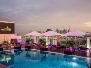 a pool on the roof of a building with umbrellas at The Canvas Dubai - MGallery Hotel Collection in Dubai